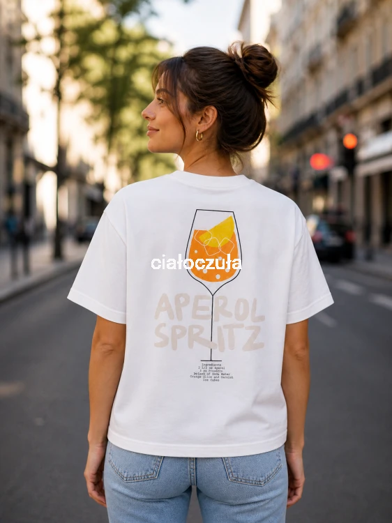 Tył bluzki z krótkim rękawem w białym kolorze z nadrukiem lampki napoju w kolorze pomarańczowym i napisem o treści Aperol Spritz. Poniżej przepis na napój