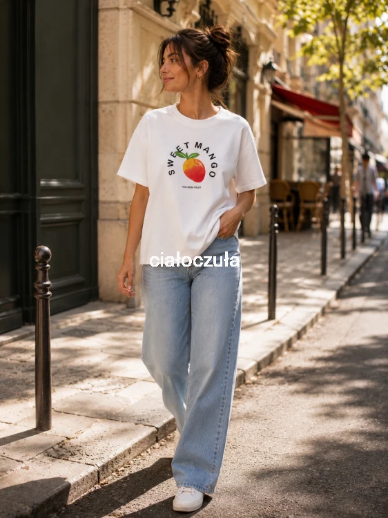 Biała bluzka z krótkim rękawem z nadrukiem owocu mango na piersiach oraz napisem Sweet Mango wraz z jeansowymi spodniami