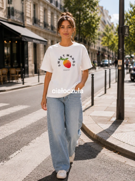 Biała bluzka z krótkim rękawem z nadrukiem owocu mango na piersiach oraz napisem Sweet Mango wraz z jeansowymi spodniami